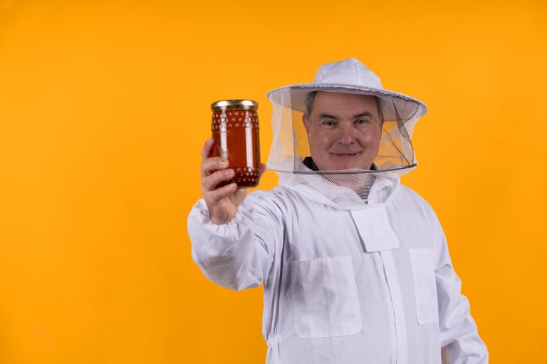 Smiling beekeeper holding golden honey jar