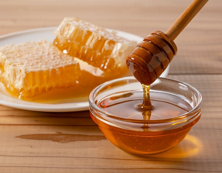 Pure organic honey dripping from wooden dipper